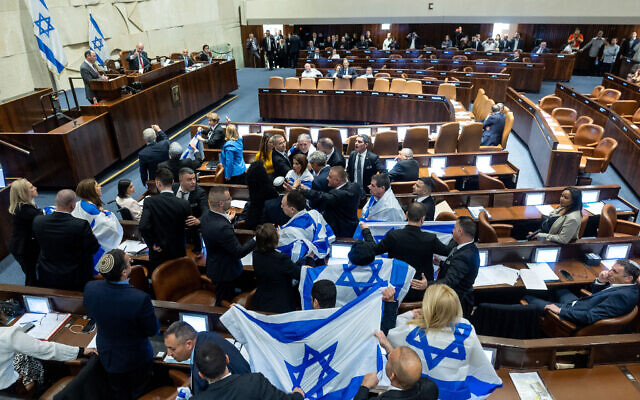 أعضاء كنيست من المعارضة يلتفون بالأعلام الصهيونية خلال نقاش في الكنيست حول أول مشروع قانون للإصلاح القضائي للائتلاف، 20 شباط 2023